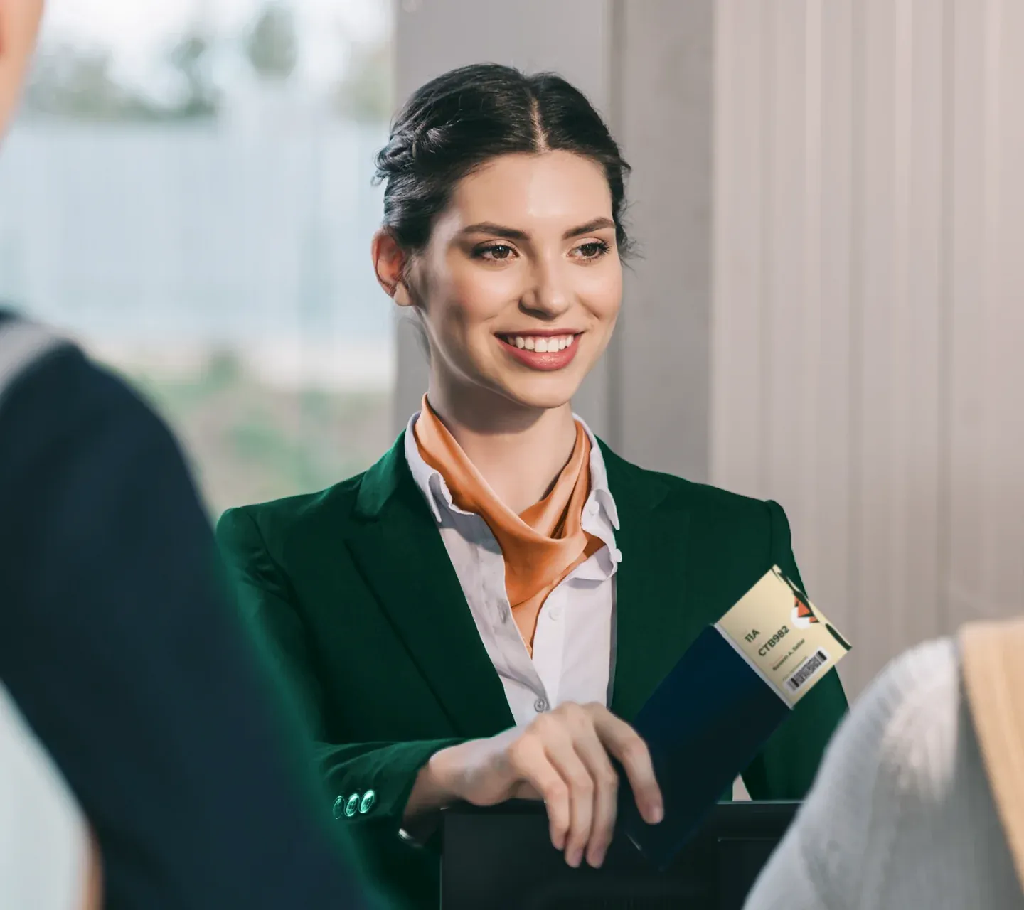 Air Sphinx staff portrait with a woman in a dark green suit holding a passport