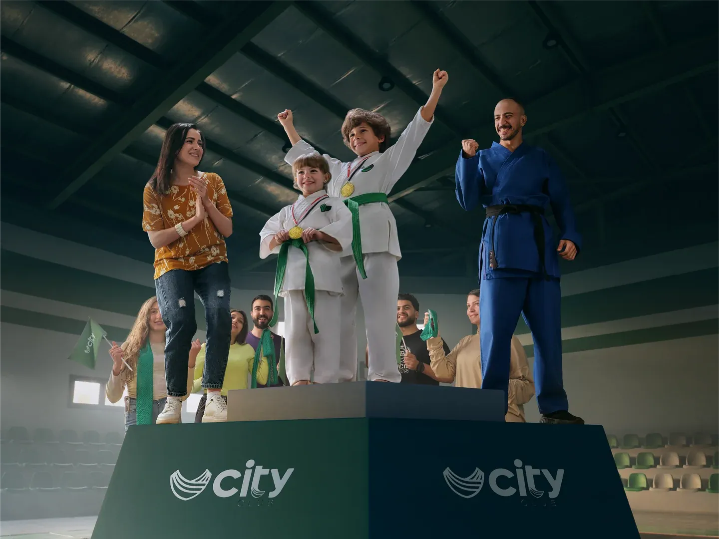 CityClub podium artwork with martial-arts children, adults and a trophy inside a sports hall