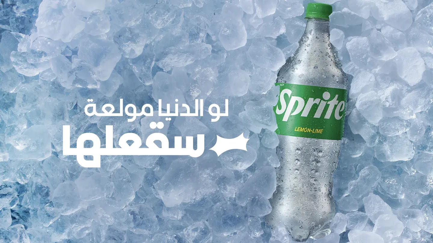 Sprite bottle covered in condensation on ice with white Arabic lettering