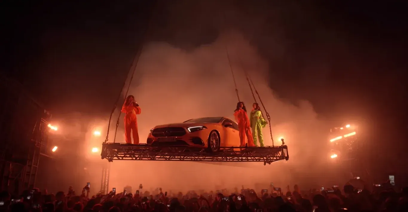 DiDi supplied AI storyboard frame of a car and performers suspended above a concert crowd